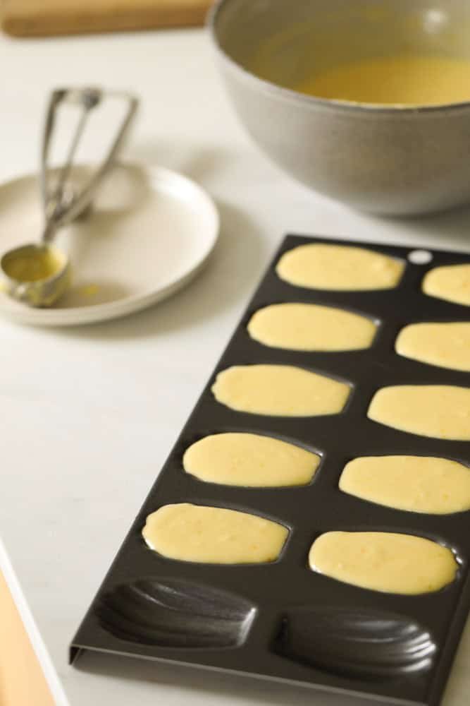 Filling a madeleine pan with batter.