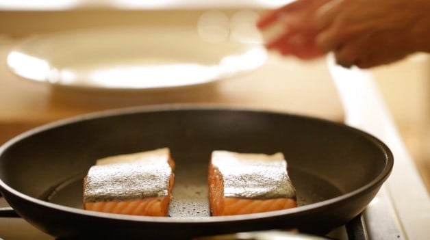 Salmon searing in a pan skin side up