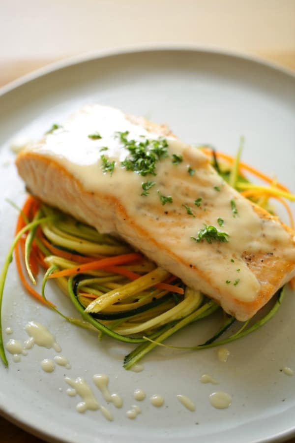 Vertical Image of Seared Salmon with a French-Style Buerre Blanc Sauce and Thinly Sliced Vegetable Nests