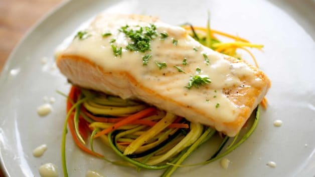 Beurre Blanc Sauce on top of Salmon and Veggie Nests on a gray plate