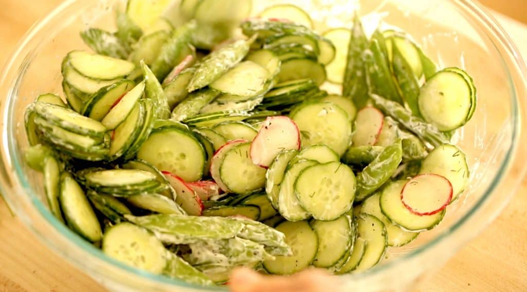 Cucumbers, radishes and snap peas mixed with sour cream 