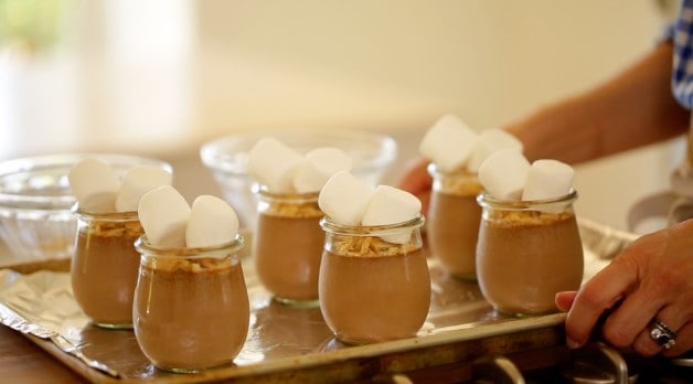 A tray of pudding pots topped with marshmallows ready to be broiled