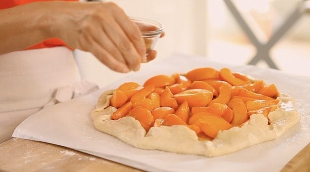 adding turbinado sugar to the top of a galette