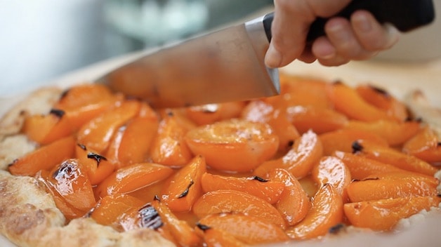 Slicing an Apricot Galette with a large chef's knife