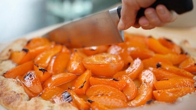 Slicing an Apricot Galette with a large chef's knife