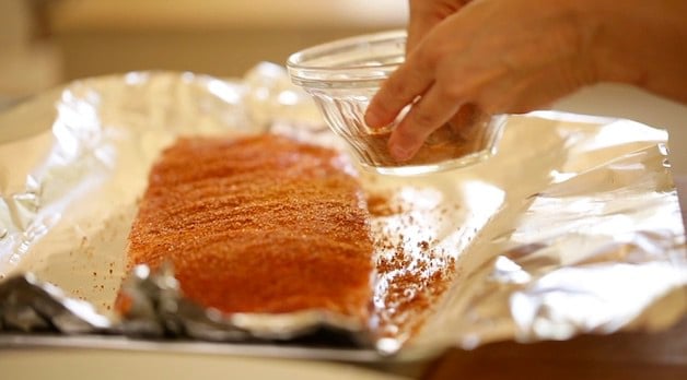 adding rib rub to a rack of ribs on foil