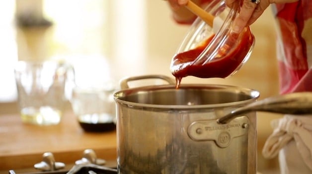 Adding ketchup to a sauce pot for homemade BBQ Sauce