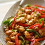 Easy Cashew Chicken Recipe in an oval platter vertical orientation