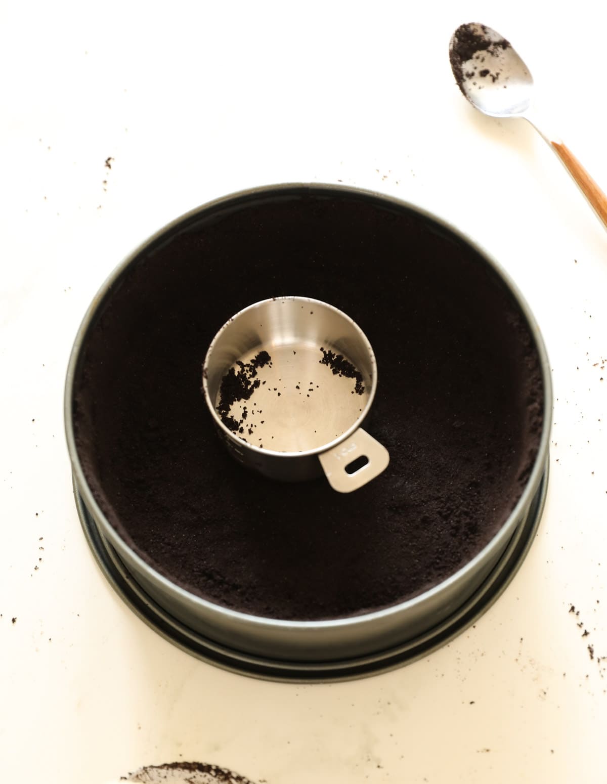 A metal measuring cup in a cookie crust tin 