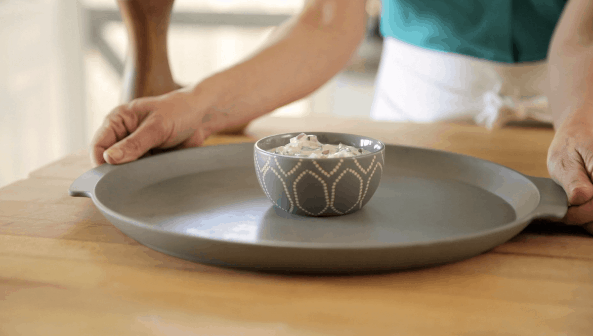 a round gray platter with a bowl of yogurt sauce in the middle