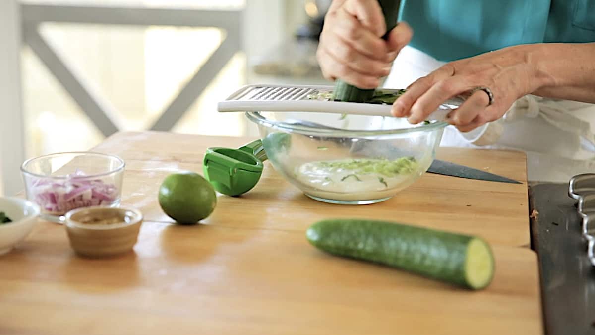 grating cucumber into a bowl