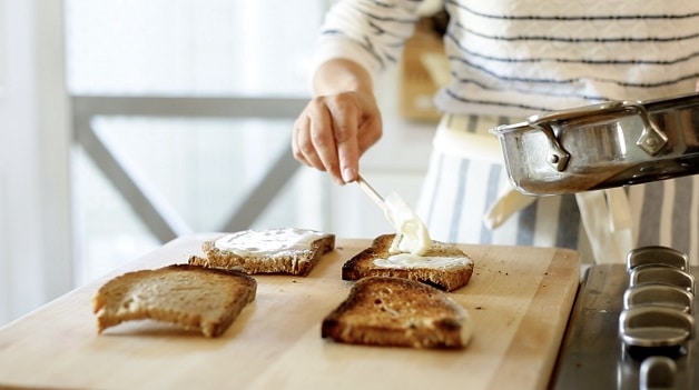 Spreading bechamel sauce over sandwich bread