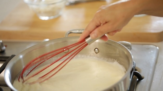 Whisking bechamel sauce in a skillet