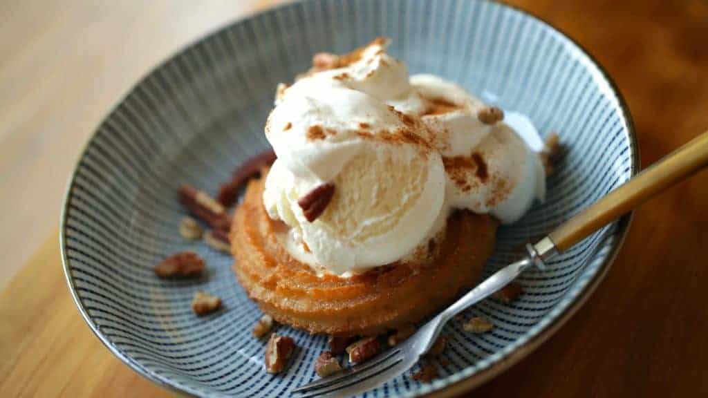 a churro sundae on a blue plate with a fork