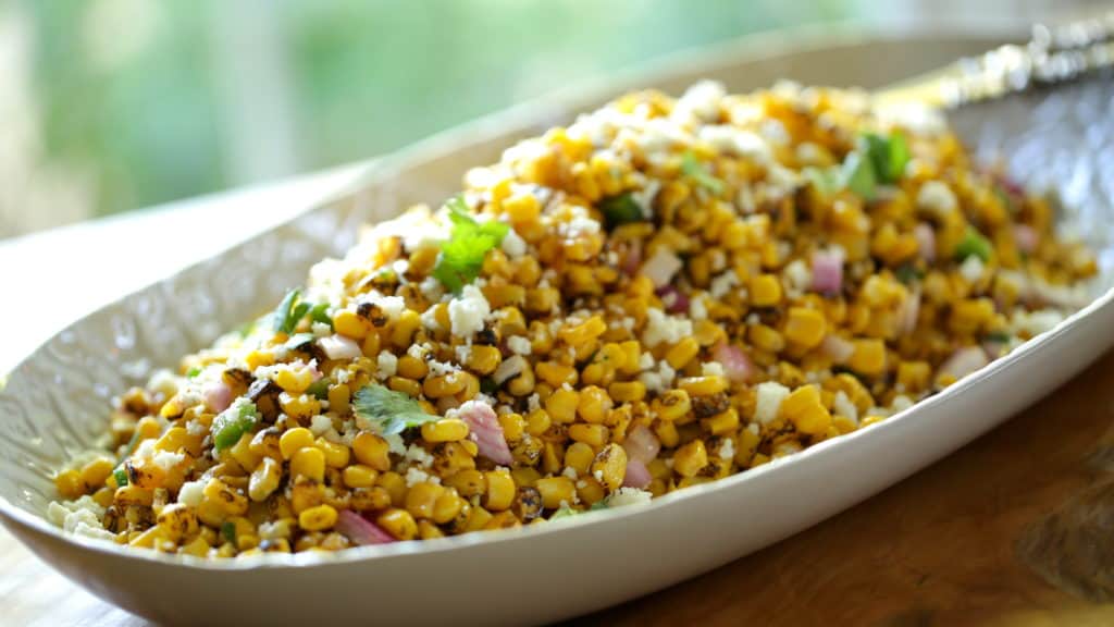 a platter filled with a charred Mexican corn salad