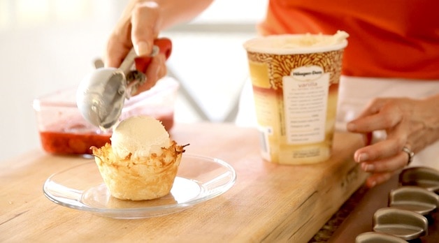 Placing a scoop of Ivanilla ice cream into a coconut ice cream basket