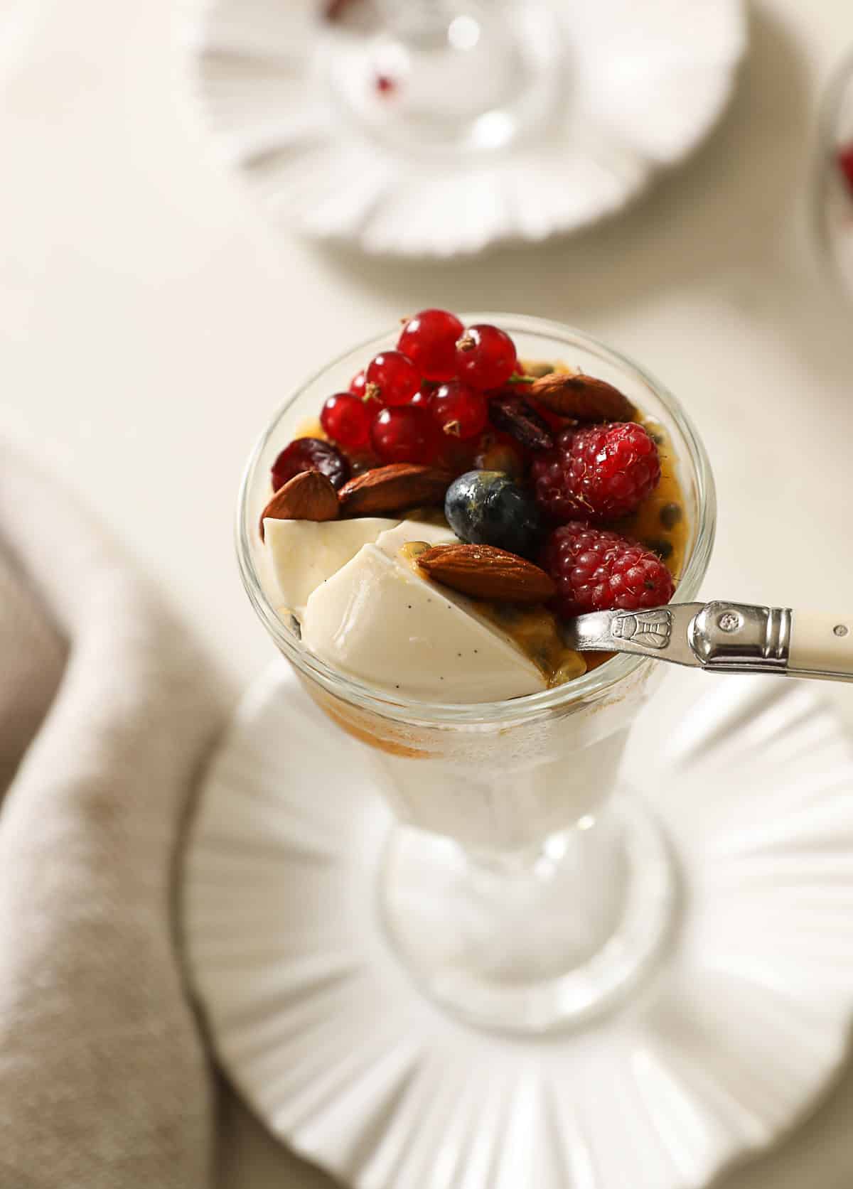 A spoon taking a bite of yogurt panna cotta.