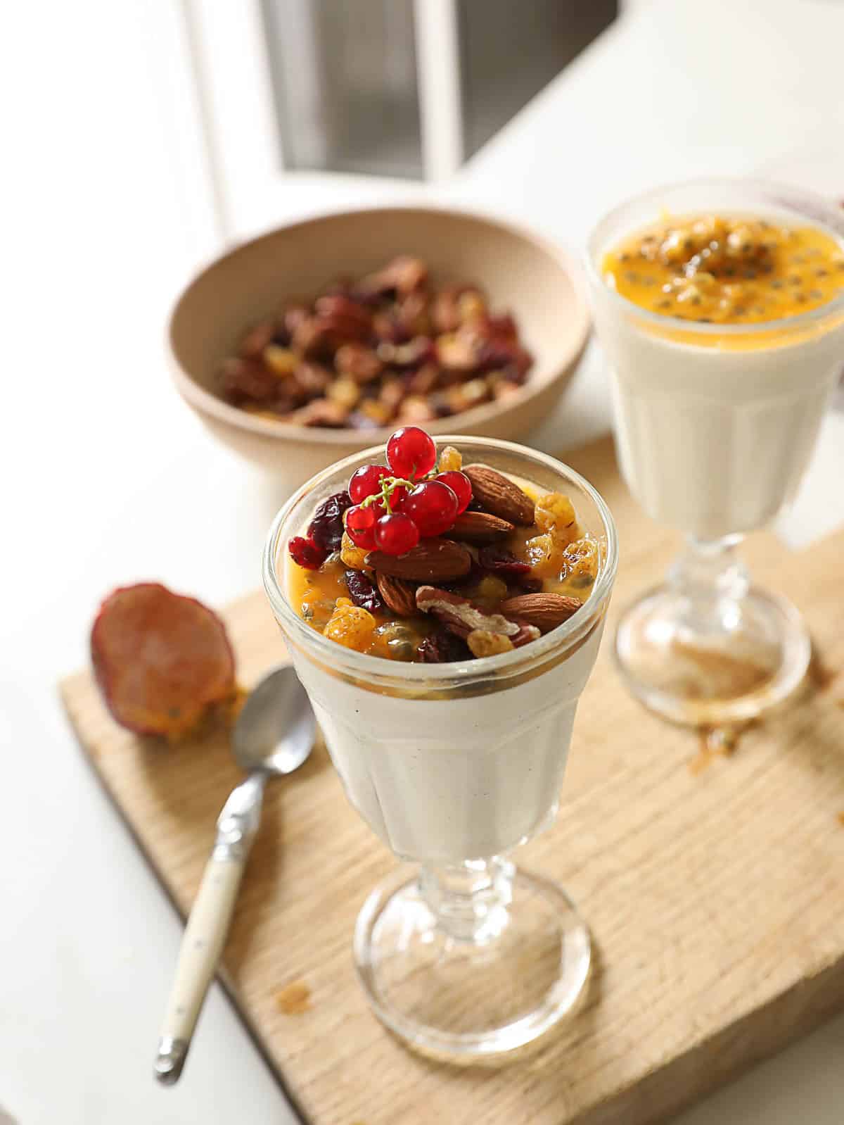 a breakfast panna cotta topped with passionfruit and nuts.