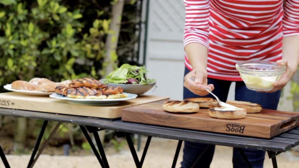 Assembling Grilled Chicken Sandwiches on outdoor tables