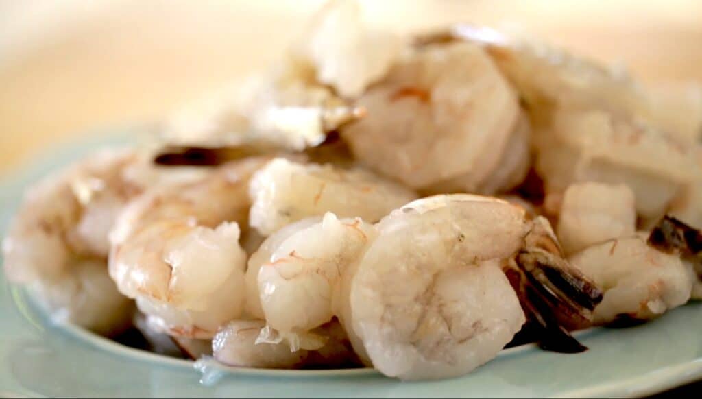 Raw shrimp on blue plate