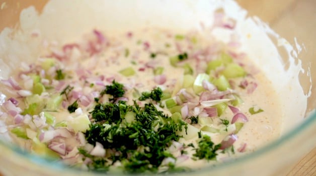 un bol de vinaigrette aux crevettes avec oignons rouges, mayo et persil