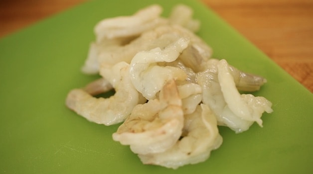 raw shrimp on green cutting board