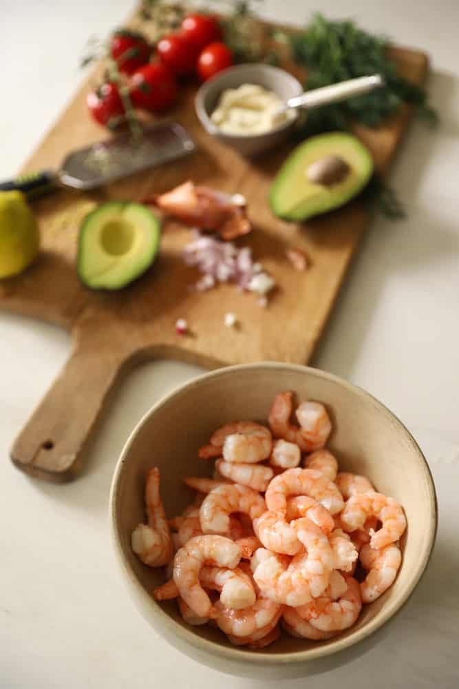 Ingredients for a shrimp salad placed on a counter.