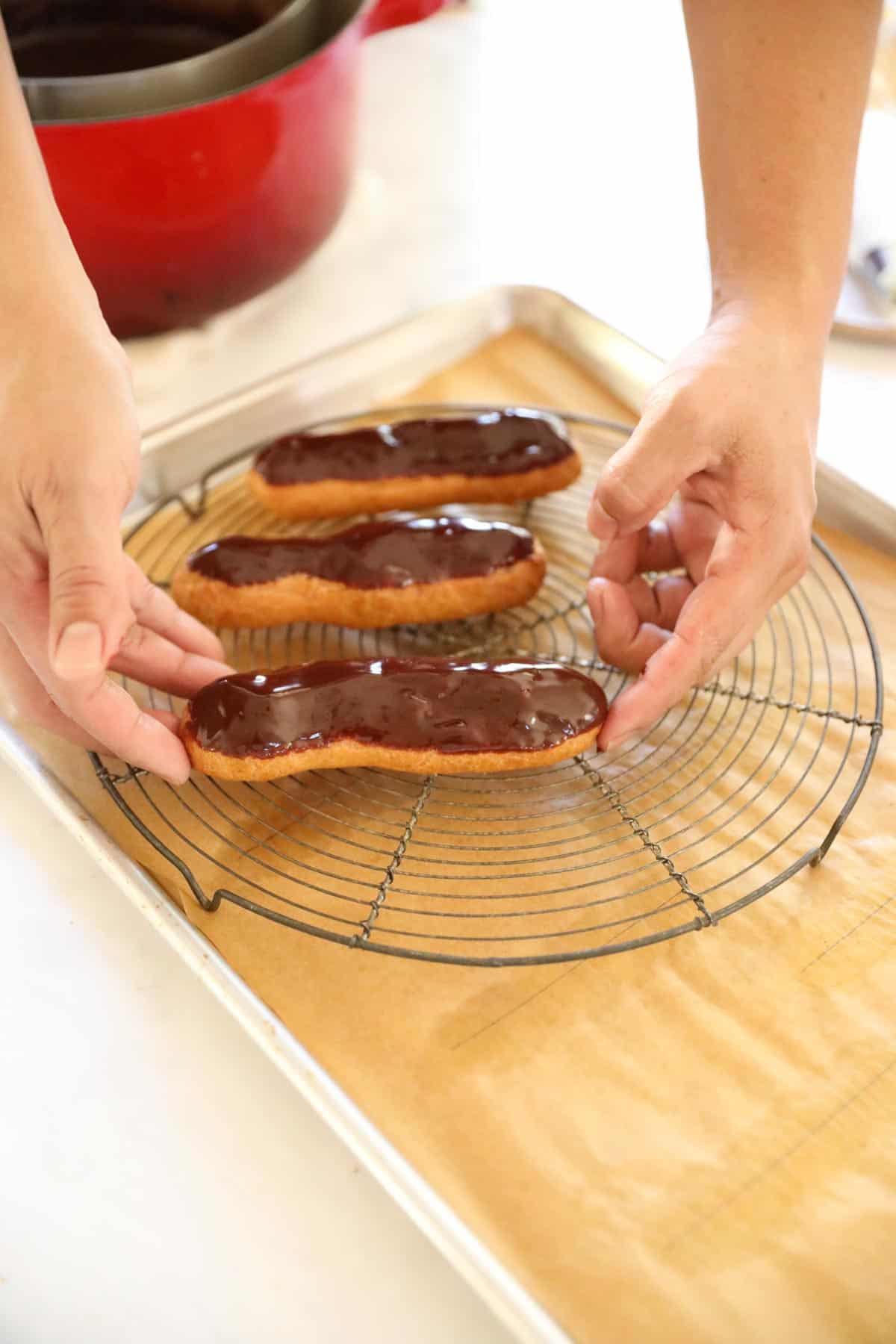 Placing glazed eclairs on a cooling rack