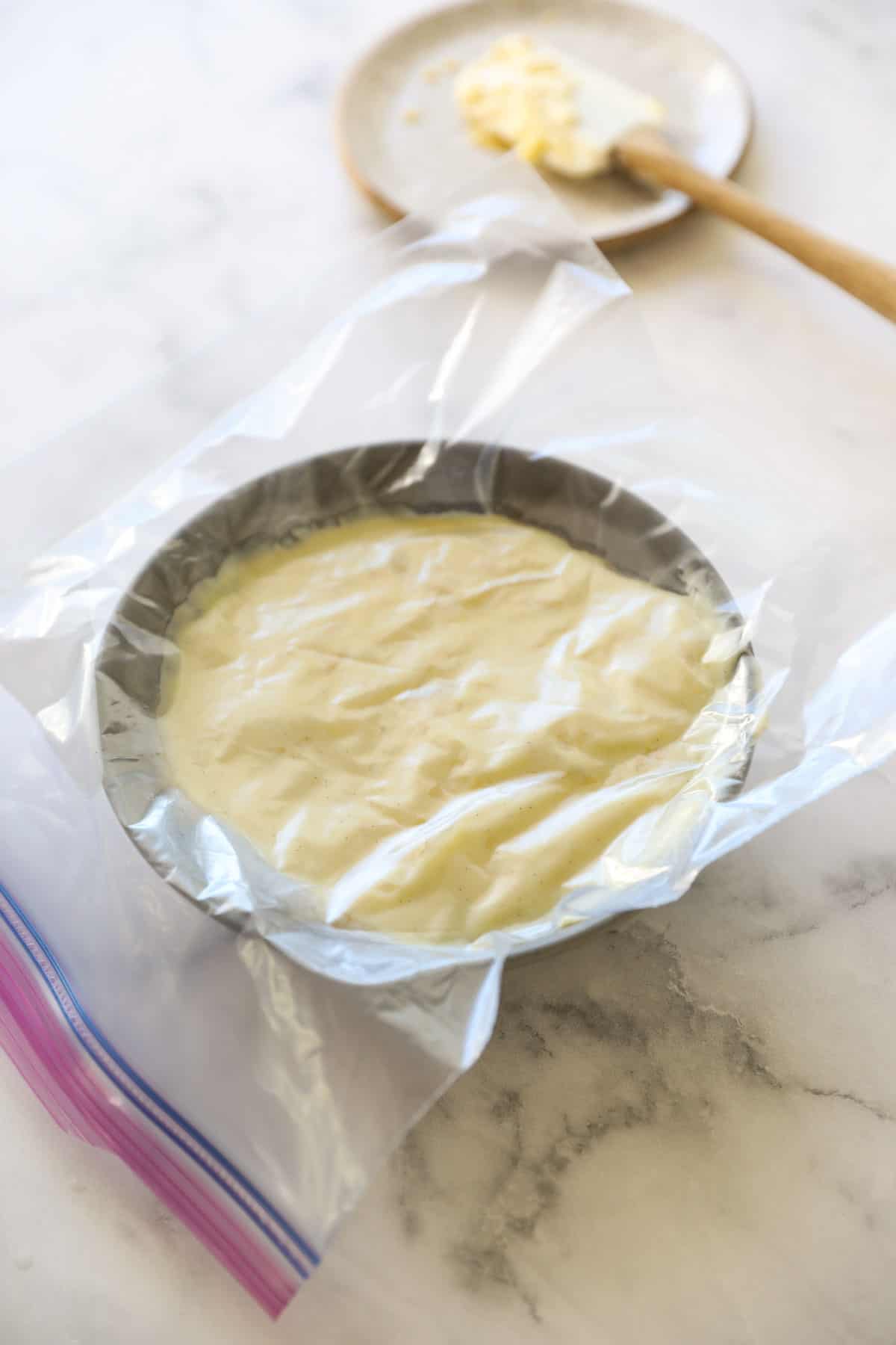 pastry cream cxooling in a bowl with plastic on top