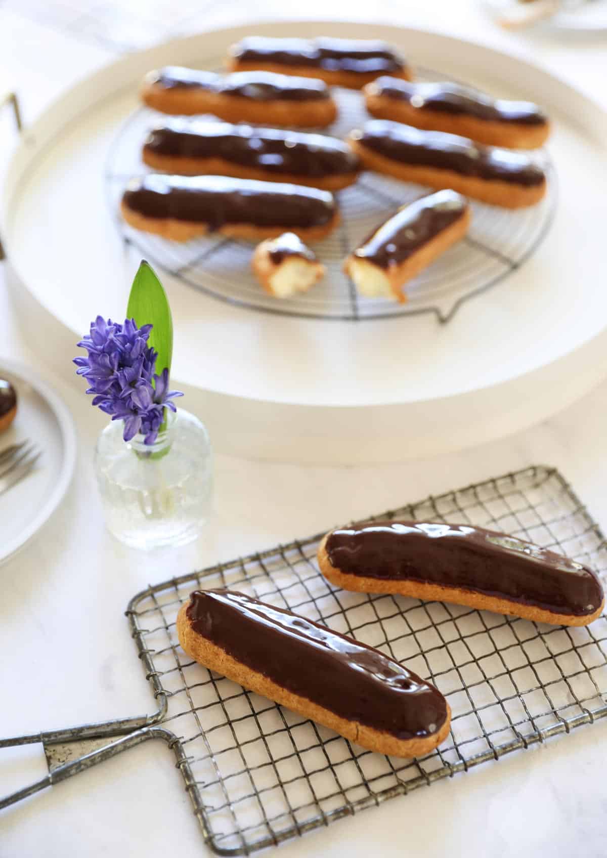 chocolate eclairs on cooling racks and tray