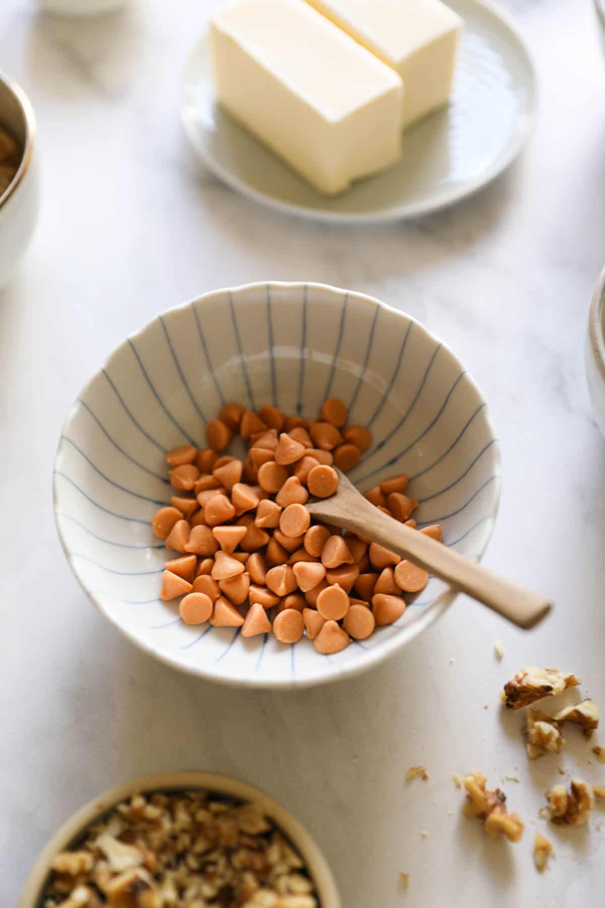 a bowl of butterscotch chips and other ingredients laid out on a counter