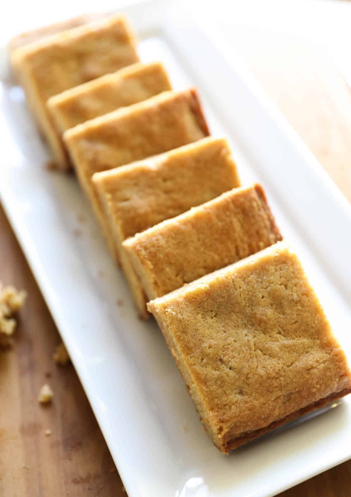 butterscotch brownies cut into squares and lined up on a plate