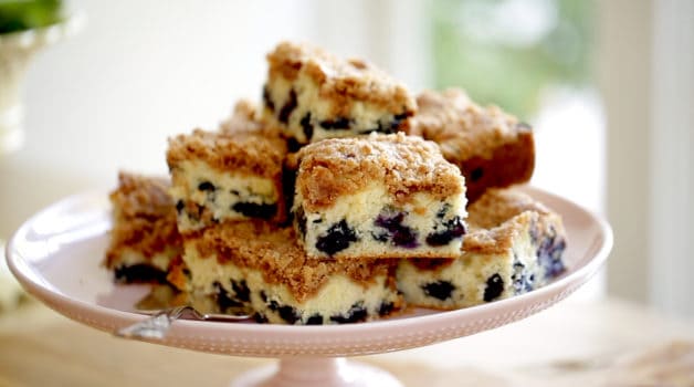 Blueberry Crumb Cake squares on a pink cake stand