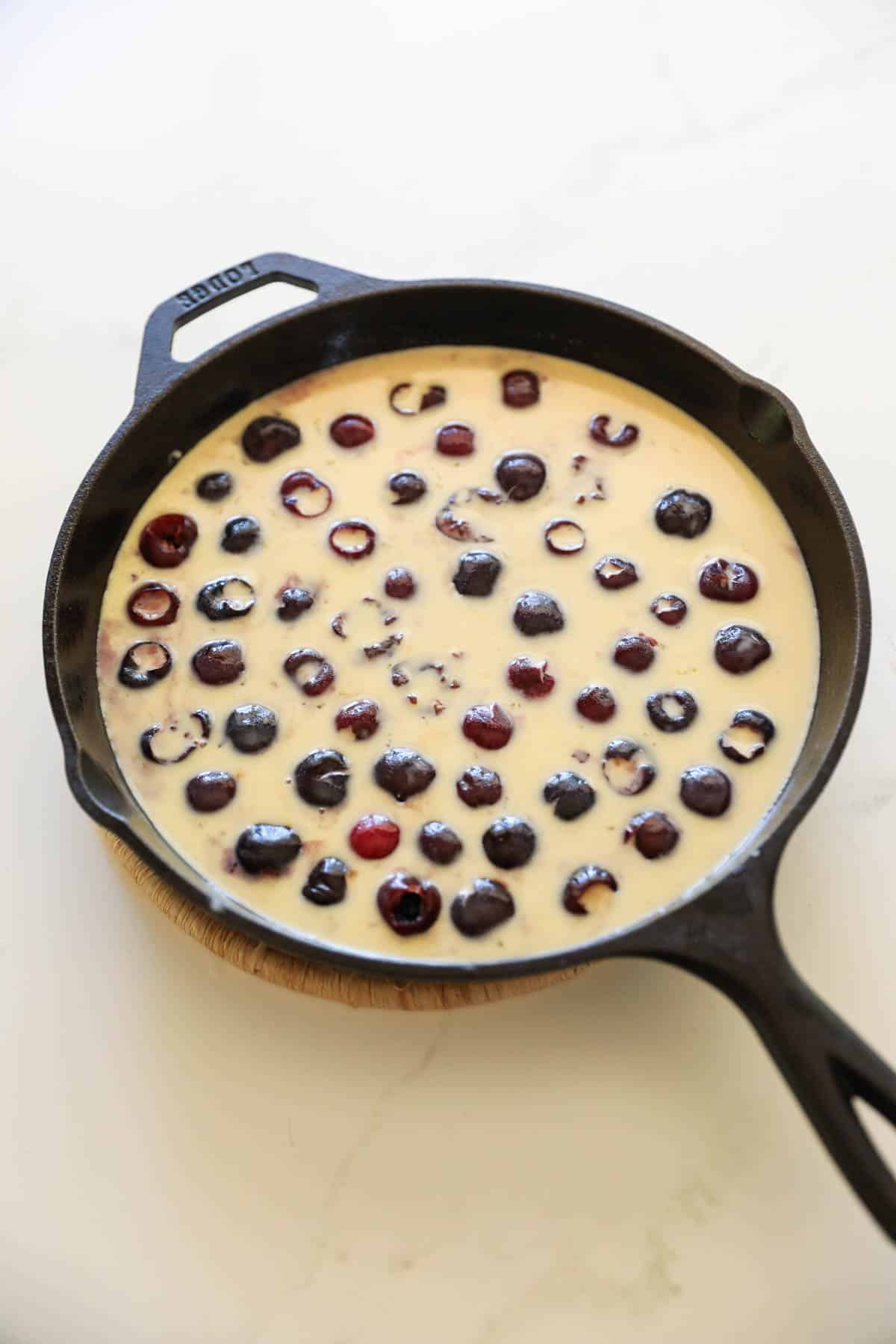 cherries in a skillet with batter poured over them