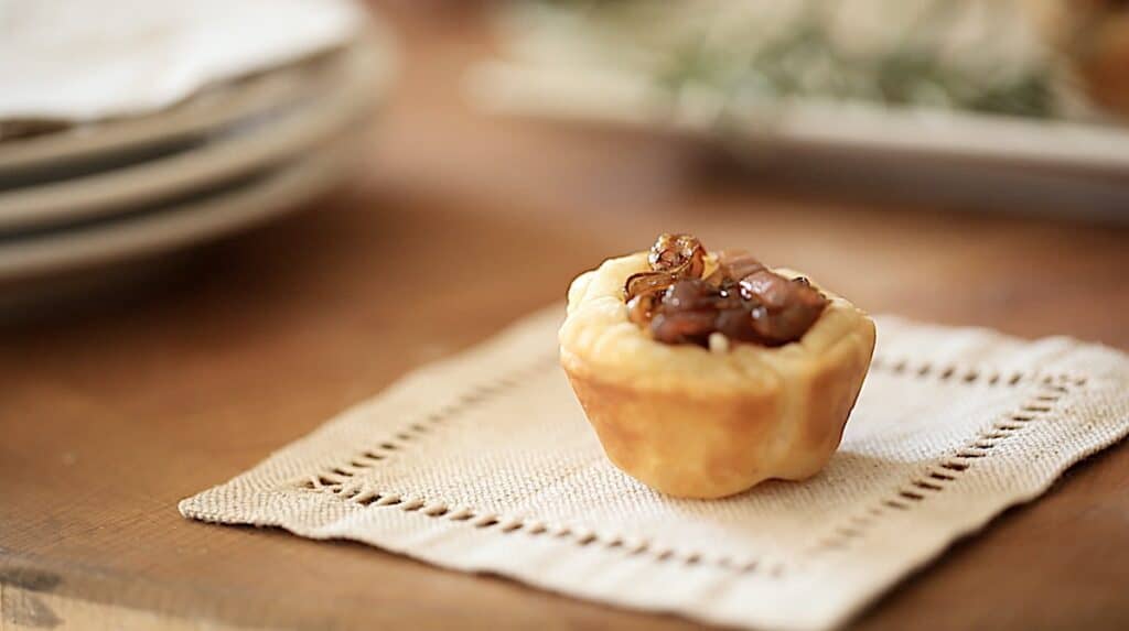 a puff pastry goat cheese tart on a linen cocktail napkin