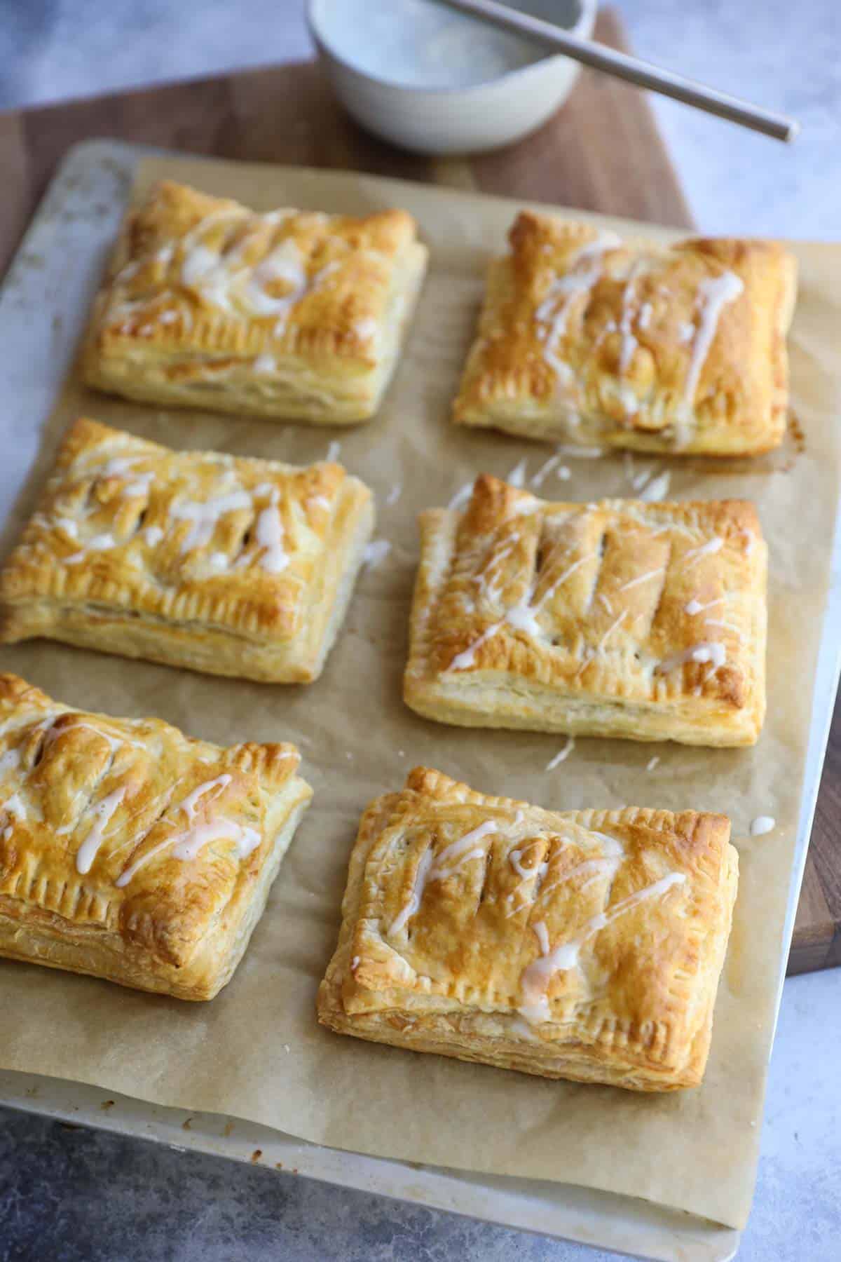 pastries glazed with frosting on a sheet pan