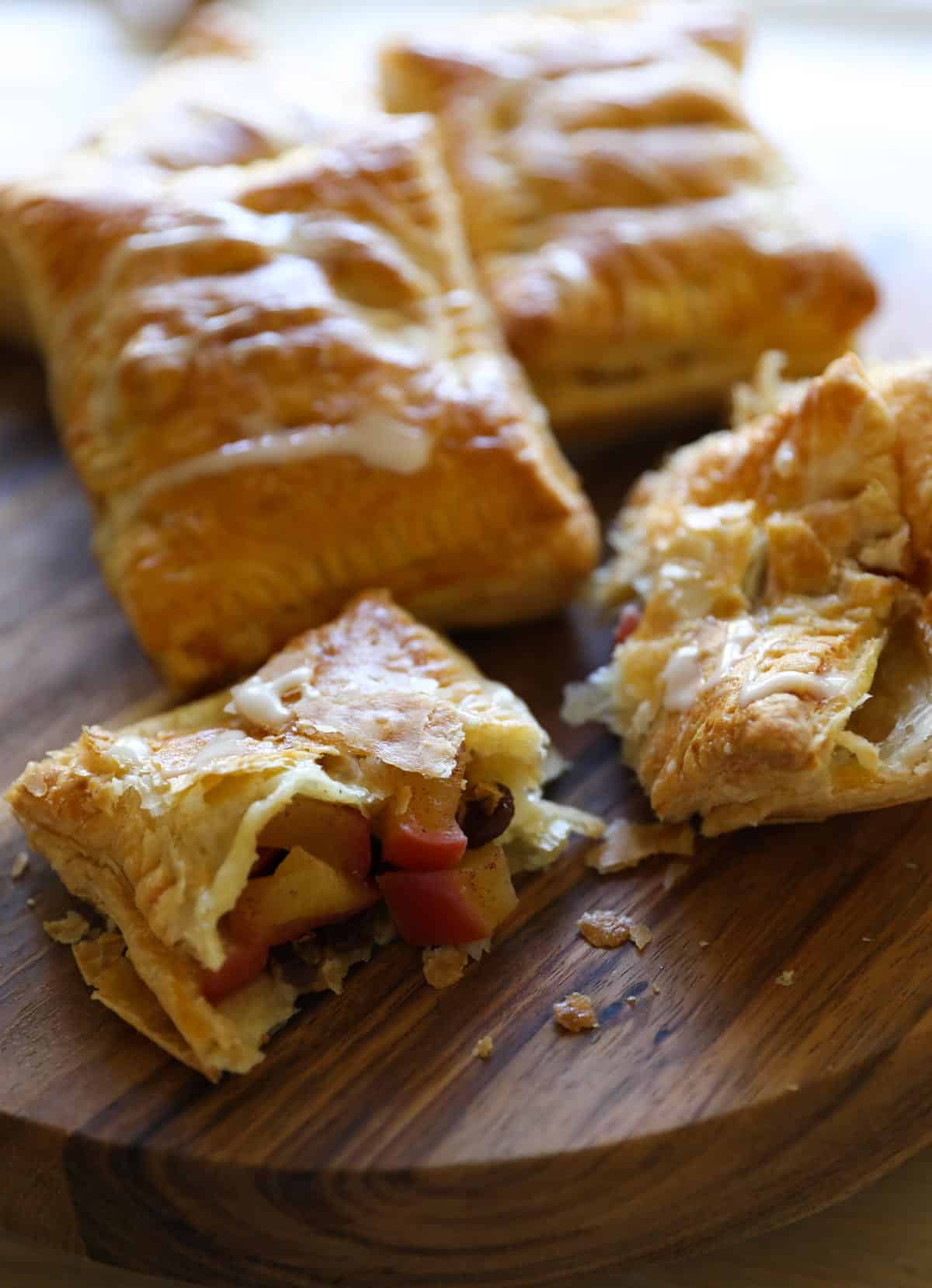 Pastries on a cutting board with one open showing the filling