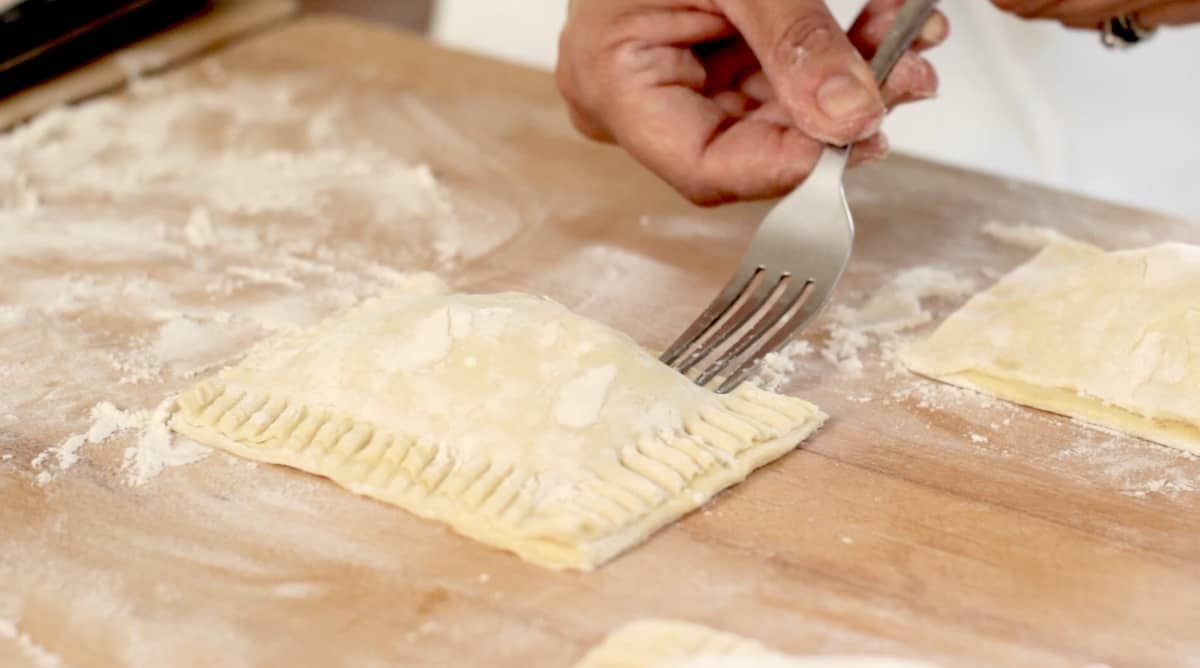 pressing pastry seem closed with a floured fork