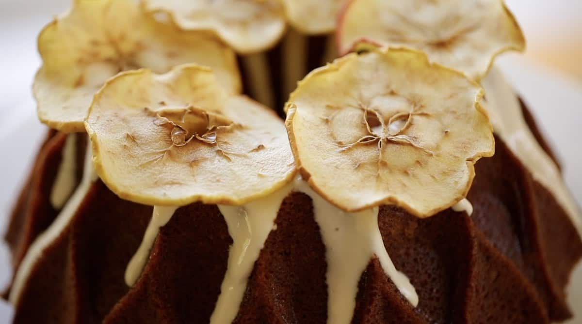Close up of dehydrated apples on a bundt cake with cream cheese frosting