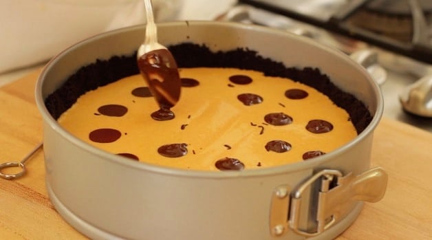 Dropping dollops of melted chocolate into cake pan filling