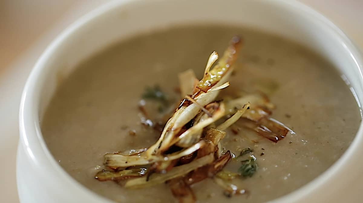 crispy leeks on top of a bowl of cream of mushroom soup