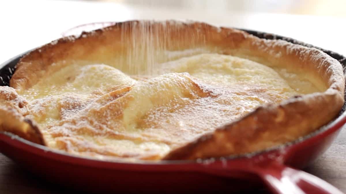 a Dutch Baby Pancake being sprinkled with sugar