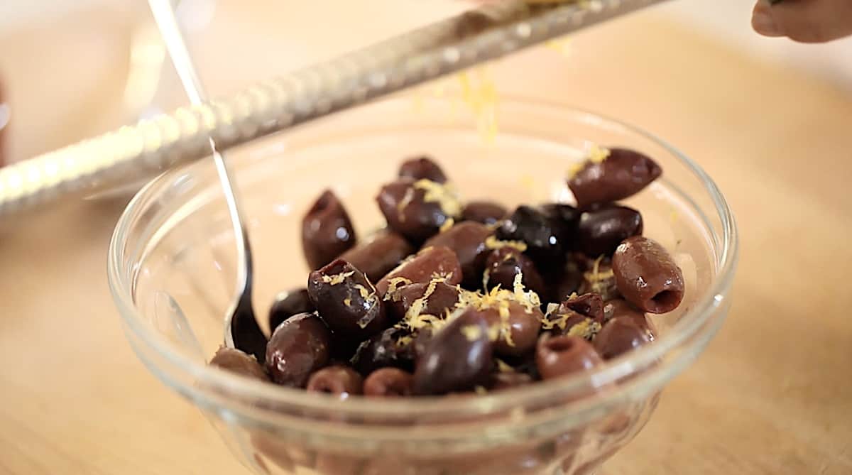 Kalamata Olives being tossed with Lemon zest