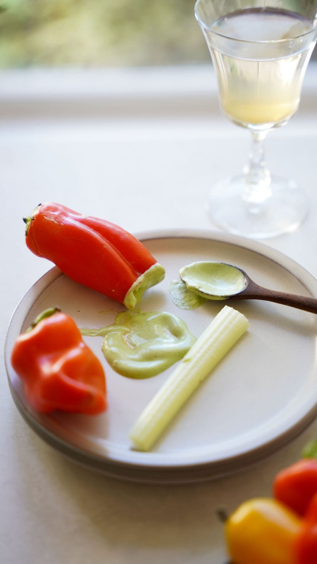 an appetizer plate with a dollop of dressing and mini red peppers.