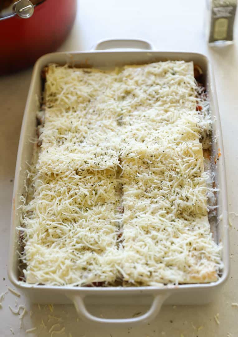 Lasagna layers made, with cheese added on top and ready to go in the oven