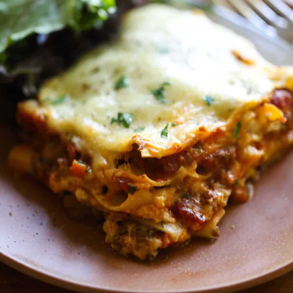 a slice of lasagna without ricotta cheese on a plate