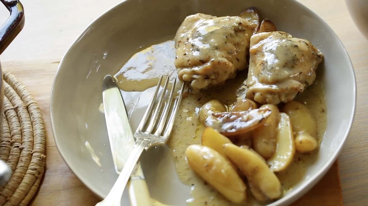 Braised Chicken Thighs on a Gray Bowl with potatoes and silverware