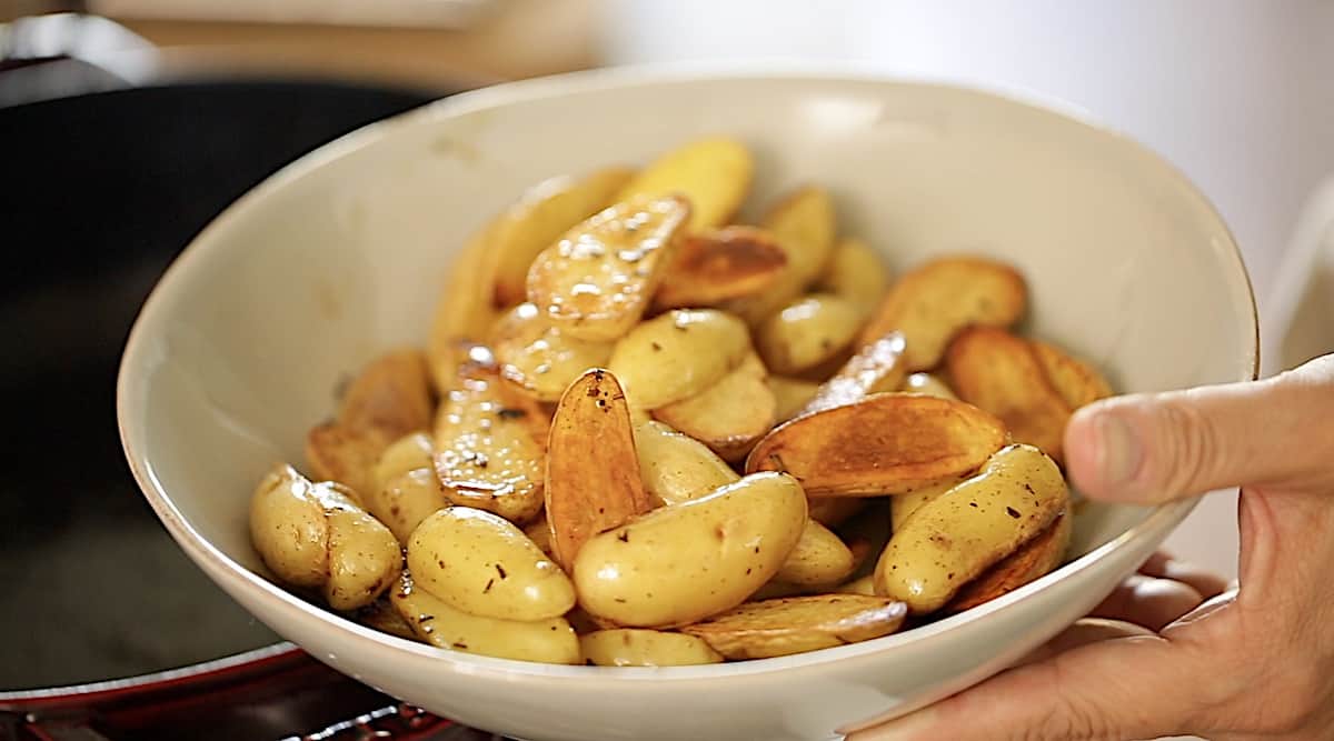 Transferring Caramelized potatoes from a pot to a bowl 