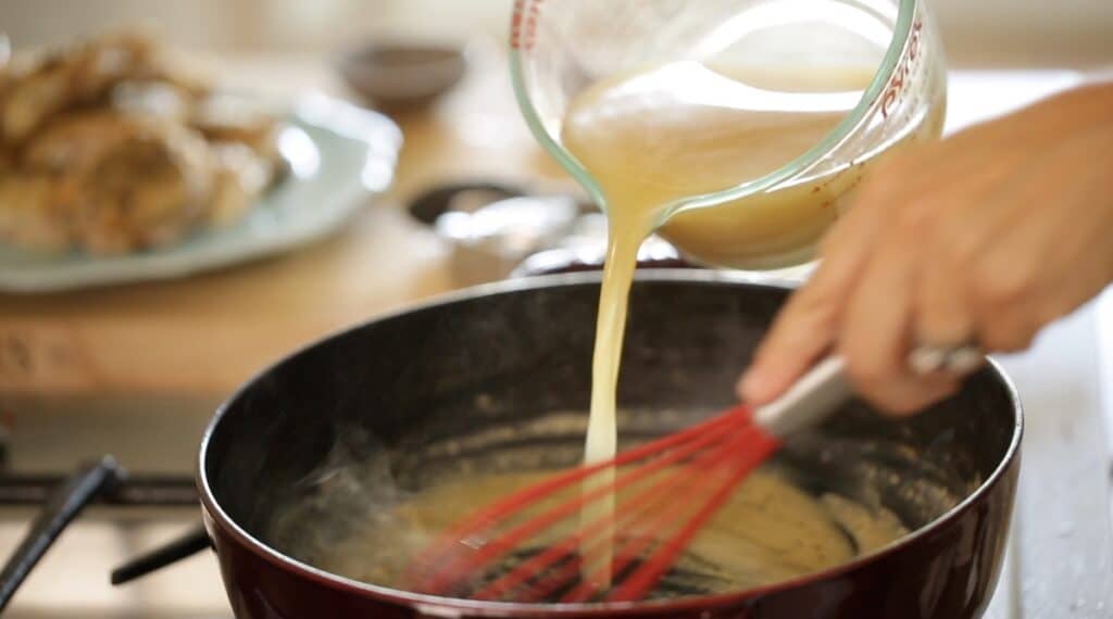 Whisking in chicken broth to a roux with a whisk