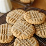 cookies cooling on a cooking rack with a pitcher of milk in the background
